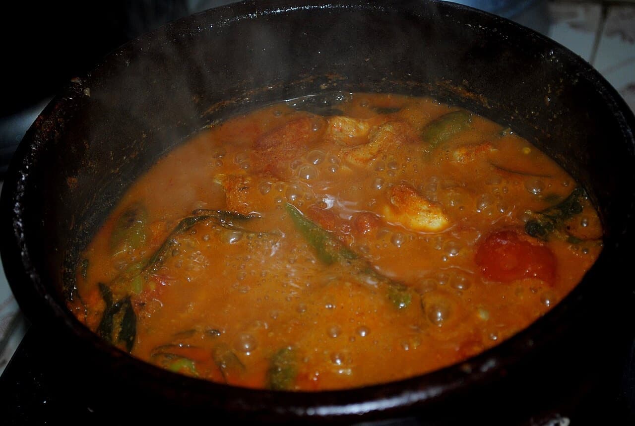 Fish curry with coconut simmering in a pot on the stove