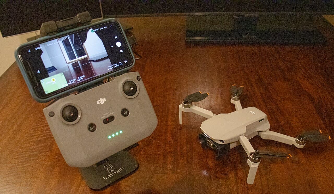 DJI Mini 2 drone with RC-N1 remote controller and phone showing live camera view