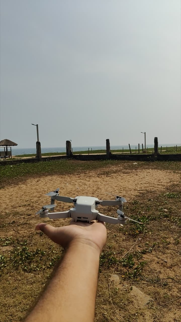 DJI Mini 2 SE drone resting on an open hand before launch