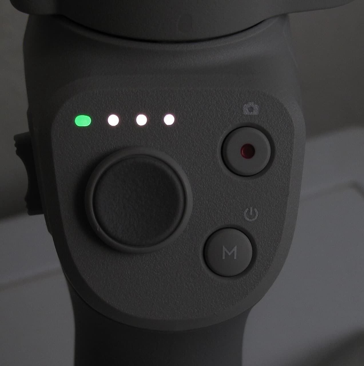 Close-up of the gimbal handle controls: joystick, record button, mode button and battery lights