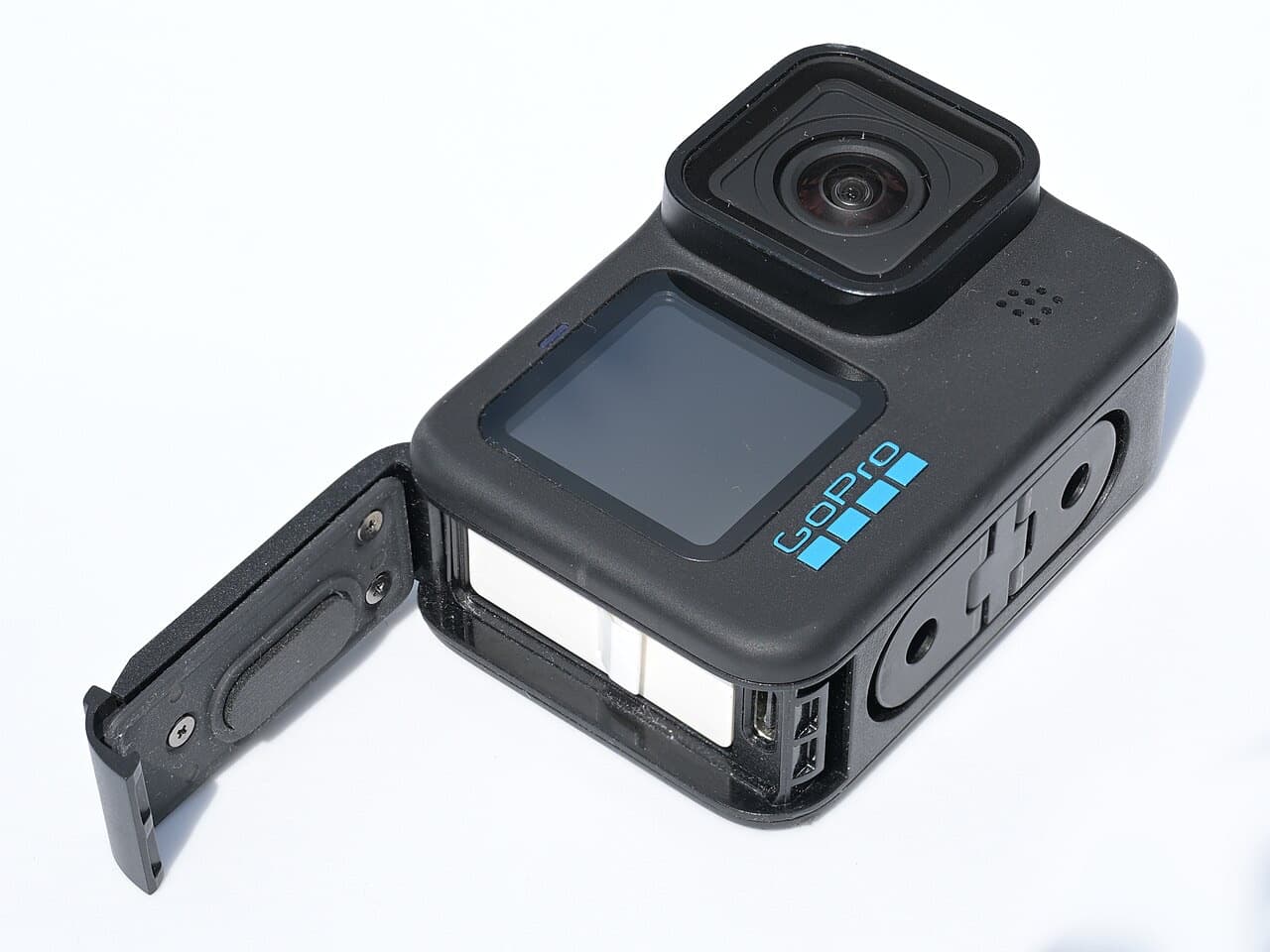 GoPro HERO10 Black with battery door open, showing battery, USB-C port and fold-out mounting fingers