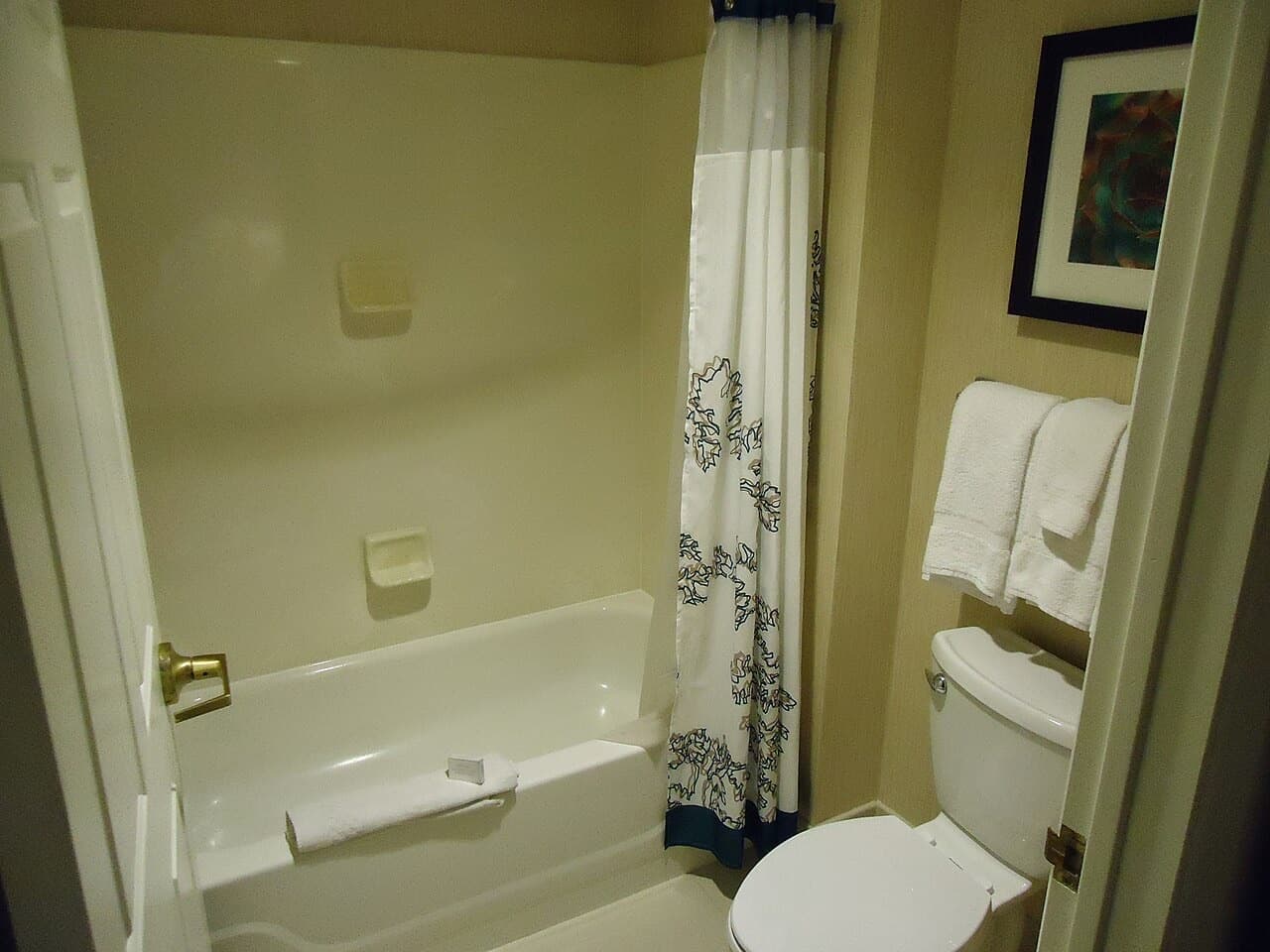 Clean bathroom with fresh white towels on the rail and bathtub