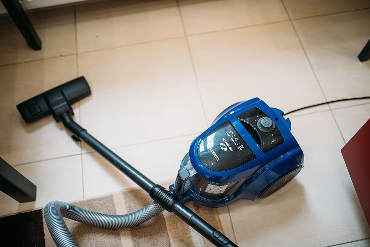 Vacuum cleaner on a tiled living-room floor during routine cleaning